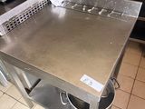 a stainless steel table in the middle of a kitchen