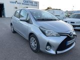 the silver toyota yaris is parked in front of a building