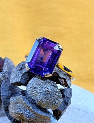 an image of a purple stone ring sitting on top of a rock