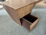 a wooden table with a drawer underneath it on a carpet