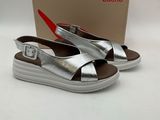 sandales en cuir argenté avec des boucles et un boîtier sur un fond blanc