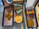 three medals and a medal in a box on a table