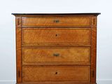 une commode en bois posée sur un parquet
