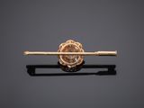 an image of a gold tie bar with a flower on it