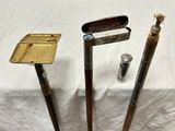 trois types différents de clubs de golf et un briquet posés sur une table