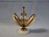 a gold and white vase with two bottles on it