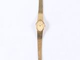 a close up of a gold wrist watch on a white surface