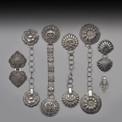 Des bracelets et des broches en argent sont présentés sur un fond blanc