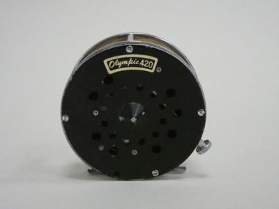 a close up of a fishing reel on a white surface