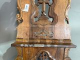 une vieille étagère en bois posée contre un mur, sur laquelle se trouve une horloge