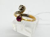 a close up of a gold ring with a ruby and diamond