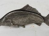 silver plated fish shaped trinket on a white surface