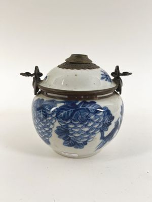 an image of a blue and white vase with a lid on a white surface