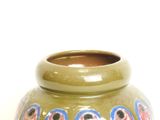 a green vase with a blue and red design on it