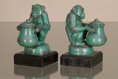 deux statues de singes posées sur une table en verre