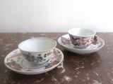 two cups and saucers sitting on a table