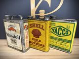 three different types of oil cans sitting on a table