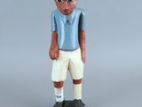 figurine représentant un homme vêtu d'une chemise bleue et d'un short blanc