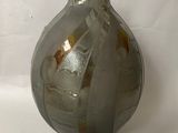 a glass vase that is sitting on a white surface