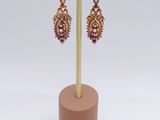 a close up of a pair of earrings on a stand
