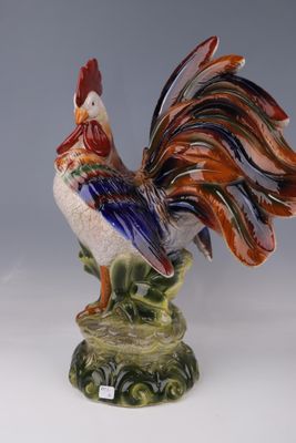 une figurine représentant un coq sur un socle vert