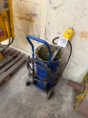 a blue bucket with a yellow handle next to a pallet