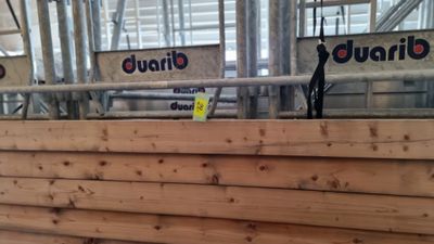un gros tas de bois dans un bâtiment, sur lequel sont accrochées des pancartes