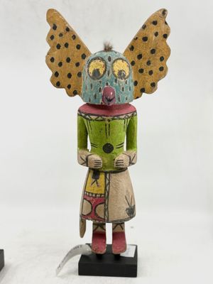 une image représentant une sculpture en bois d'une femme avec un papillon sur la tête