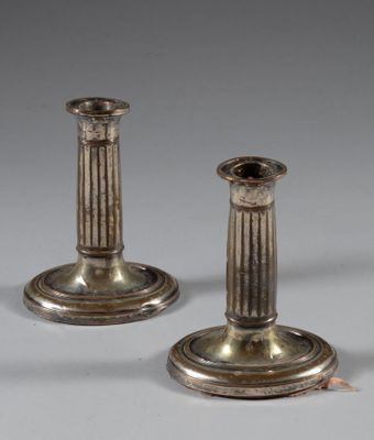 une paire de bougeoirs anciens en argent sur fond gris