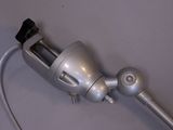 a silver blow dryer with a black handle on a table