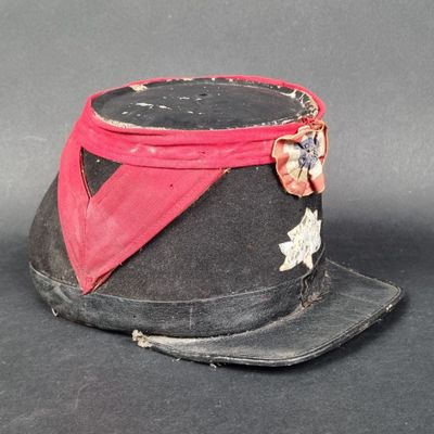 un chapeau noir orné d'un ruban rouge et d'une étoile