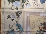 a picture of a table cloth with a picture of flowers and birds on it