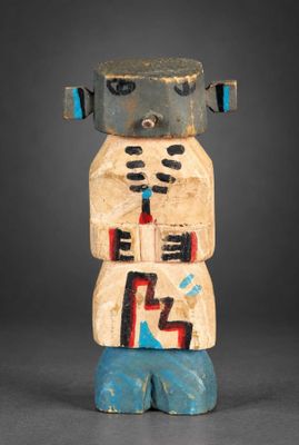 un gros plan sur une statue en bois représentant un robot, posée sur une surface grise
