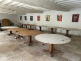 une pièce avec des tables et des chaises, et des tableaux accrochés au mur
