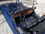 a blue car that is parked on a cobblestone street