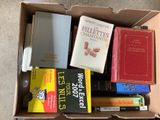 many books in a box that are sitting on the floor