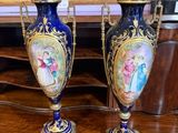 deux vases posés sur une table devant un tableau