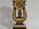 une horloge noire et or posée sur une surface blanche