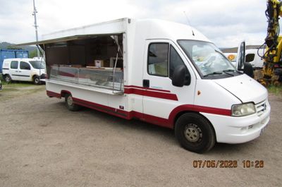 un food truck blanc et rouge garé sur un parking
