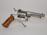 a close up of a revolver with a wooden handle on a white surface