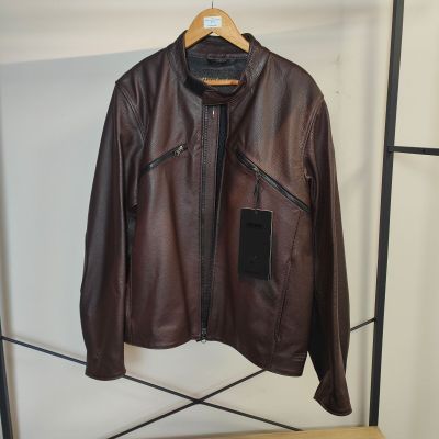 une veste en cuir marron suspendue à un porte-manteau dans une pièce