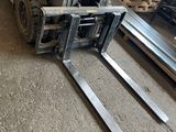 a forklift that is parked next to a pile of pallets