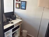 un bureau sur lequel est posé un ordinateur portable, dans un coin de la pièce
