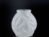 un gros plan d'un vase blanc posé sur une surface noire