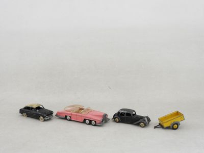 trois petites voitures sont alignées sur une surface blanche