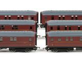 four red and blue train cars sitting next to each other on a white surface