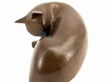 sculpture of a cat sleeping on a pillow on a white surface