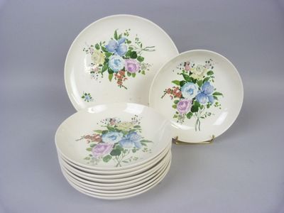 a stack of plates with flowers on them on a table