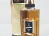 Le flacon de parfum se trouve à côté de la boîte, sur la table.