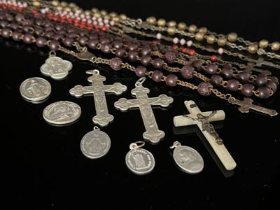 several rosary beads and a cross on a table with a black background